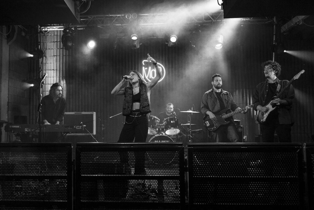 Angelina Mango canta sul palco durante un concerto dal vivo insieme alla sua band.