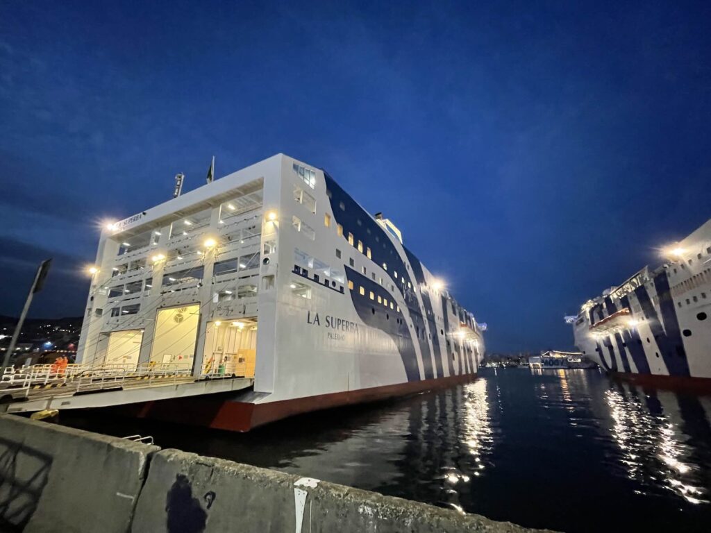 **Legenda:**
Il traghetto per Palermo pronto alla partenza: per chi vuole portare l’auto in Sicilia e viaggiare con più libertà, la nave resta una soluzione da valutare.

Traghetto La Suprema attraccato in porto di Genova la sera, pronto per la partenza verso Palermo, Sicilia.
