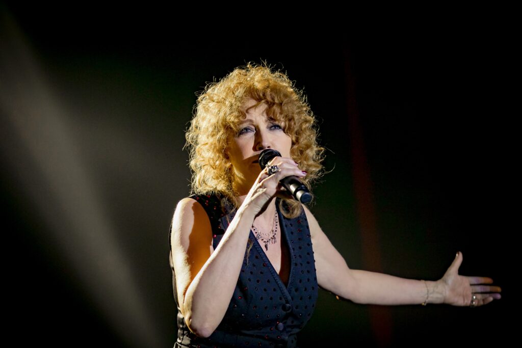 Fiorella canta Fabrizio e Ivano: Anime Salve in Sicilia 2026 – date, luoghi e prezzi a Messina, Catania e Palermo 1 Fiorella Mannoia canta dal vivo sul palco con il microfono in mano durante un concerto