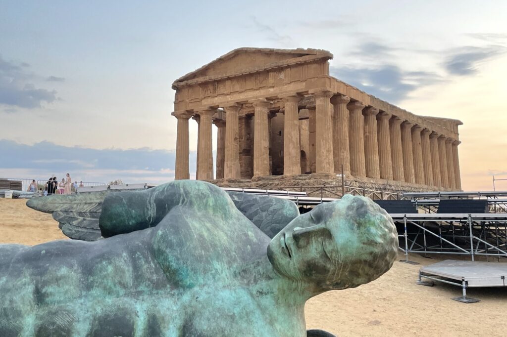 Parchi archeologici gratis in Sicilia il 4 novembre 2026: siti e orari 1 Il Tempio della Concordia nella Valle dei Templi di Agrigento al tramonto, con in primo piano la scultura in bronzo dell'Icaro caduto di Igor Mitoraj